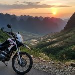a motorcycle parked on a road with a view of the mountains