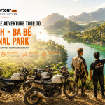 two men standing on a cliff overlooking a body of water Vu linh motorbikes tour